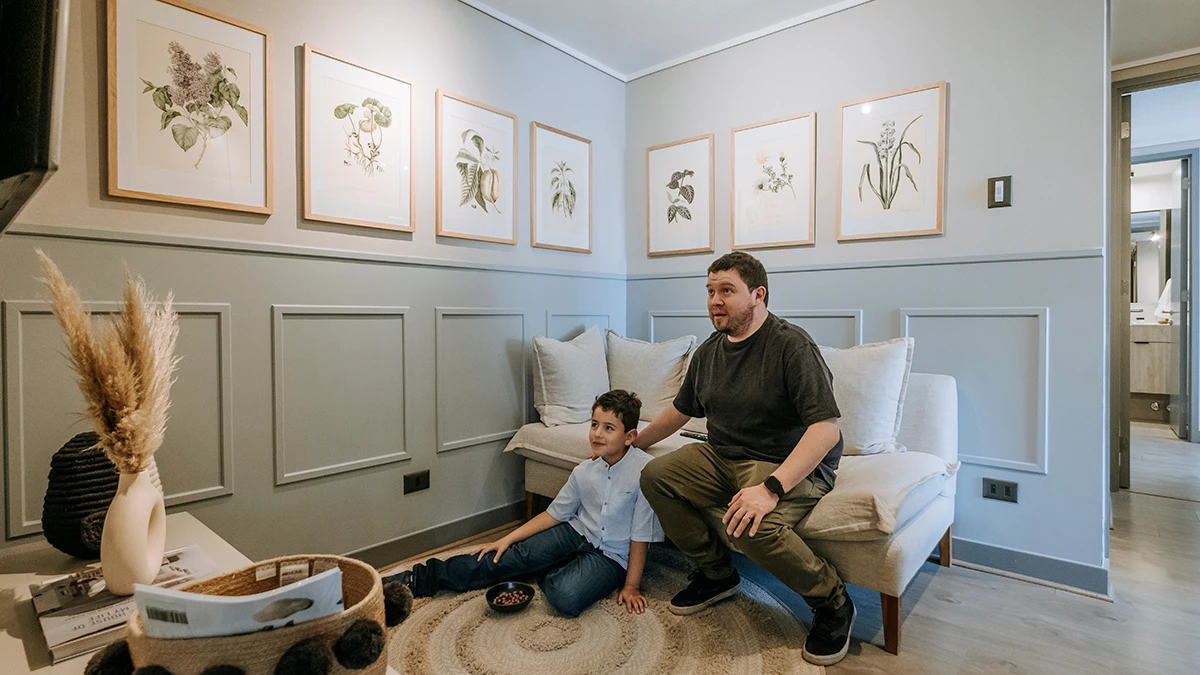 Padre e hijo viendo tv en sala de estar Edificio Insigne