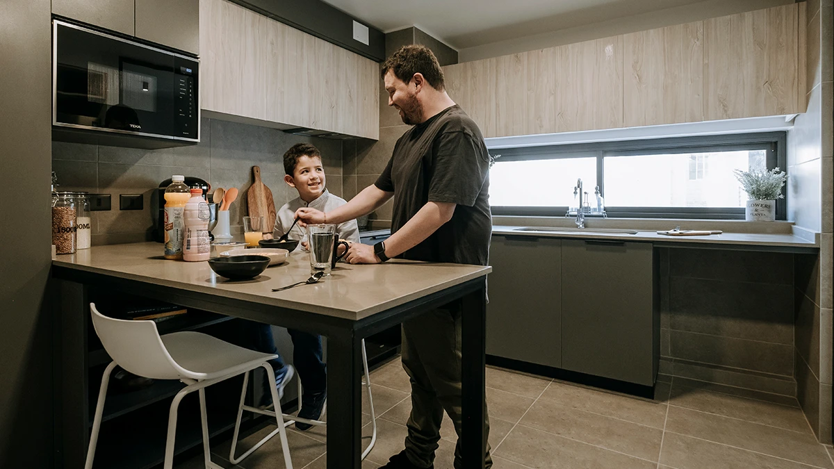 Padre e hijo disfrutando de cocina cerrada Edificio Insigne